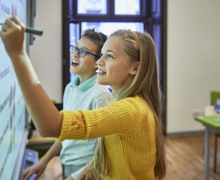 two school friends using the smart board for their project